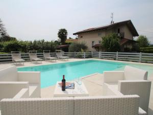 a bottle of wine sitting on a table next to a swimming pool at Villa Giuseppina by Interhome in Besozzo