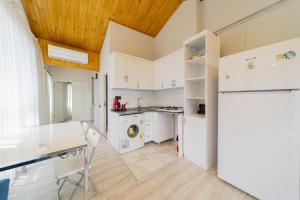 uma cozinha com armários brancos e um tecto de madeira em Convenient and Scenic Flat in Antalya em Hurmaköy