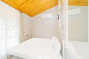 Cette chambre blanche dispose d'un lit et d'une fenêtre. dans l'établissement Convenient and Scenic Flat in Antalya, à Hurmaköy