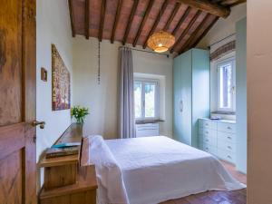 um quarto com uma cama branca e 2 janelas em Apartment Casa Alessia by Interhome em Tavarnelle in Val di Pesa