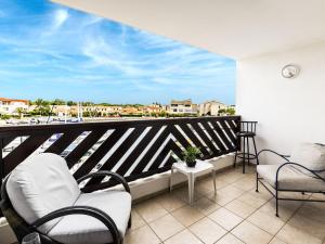 einen Balkon mit Stühlen und Stadtblick in der Unterkunft Apartment Les Quais de L'Amirauté-8 by Interhome in Saint Cyprien Plage