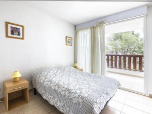 ein Schlafzimmer mit einem Bett und einem großen Fenster in der Unterkunft Apartment Les Quais de L'Amirauté-8 by Interhome in Saint Cyprien Plage