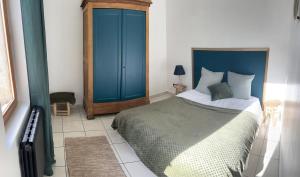 um quarto com uma cama e um armário azul em La Ferme de Valeuse em Morienval