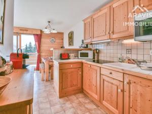 a kitchen with wooden cabinets and a counter top at Appartement Le Grand-Bornand, 2 pièces, 4 personnes - FR-1-391-110 in Le Grand-Bornand