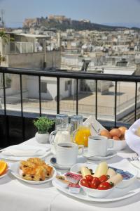 - une table avec des assiettes de petit-déjeuner sur un balcon dans l'établissement Dryades & Orion Hotel, à Athènes