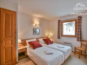 a bedroom with two beds and a desk and a window at Appartement Le Grand-Bornand, 5 pièces, 8 personnes - FR-1-391-94 in Le Grand-Bornand