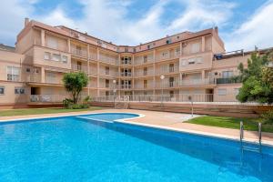 un bâtiment avec une piscine en face d'un bâtiment dans l'établissement Amplio Canet, à Canet d'En Berenguer