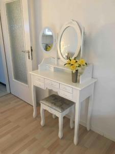 tocador blanco con espejo y jarrón de flores en Eifelliebe Rott, en Roetgen