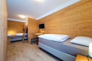 twee bedden in een kamer met een houten muur bij Gass Apartment A in Laion