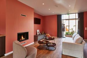 a living room with orange walls and a fireplace at Kamerrijk in Pepingen