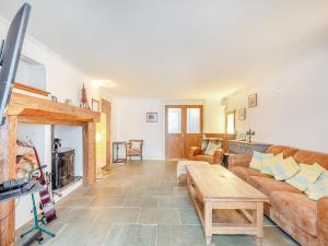 a living room with a couch and a table at Mill Barn in Torbeg