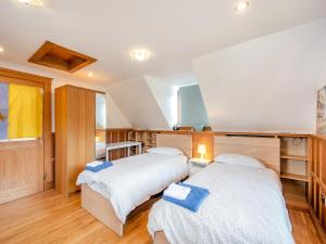 two beds in a room with wooden floors at Mill Barn in Torbeg