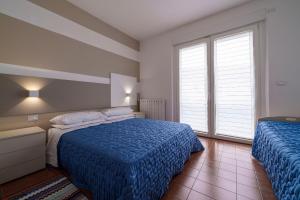 um quarto com 2 camas e uma janela em Casa Vacanza Acqua Dolce em Maccagno Inferiore