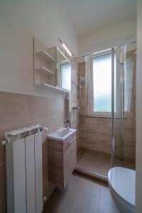 a bathroom with a toilet and a sink and a shower at Casa Vacanza Acqua Dolce in Maccagno Inferiore +20 photos