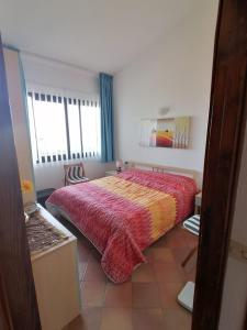 Villetta dei Ginepri في كوستا باراديسو: غرفة نوم مع سرير مع لحاف احمر