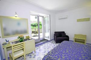 a bedroom with a bed and a desk and a chair at Cavalluccio Marino in Anacapri