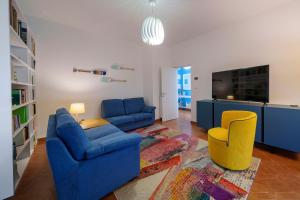 a living room with a blue couch and a yellow chair at Casa Vacanza Acqua Dolce in Maccagno Inferiore