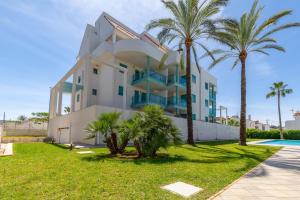 a house with palm trees in front of it at Pont Sec Apartments in Denia