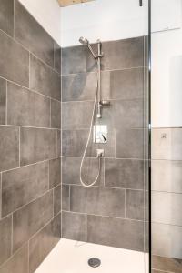 um chuveiro numa casa de banho com azulejos cinzentos em Appartement Bergpanorama Brandegg em Wagrain