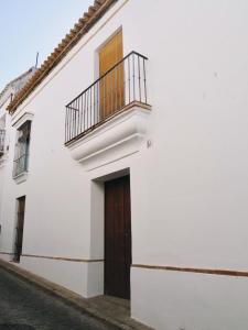 a white house with a door and a balcony at Carmona Center Apartment in Carmona