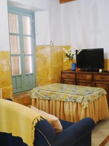 a living room with a table and a tv at Carmona Center Apartment in Carmona