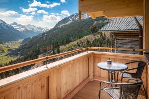 uma varanda com mesa, cadeiras e montanhas em Appartement Bergpanorama Brandegg em Wagrain