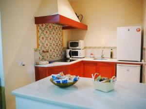 a kitchen with red cabinets and a bowl on a counter at Carmona Center Apartment in Carmona