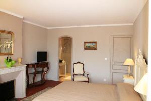 a bedroom with a bed and a desk and a television at LA MAISON DE JUSTINE in Grimaud