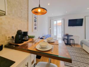 a kitchen with a table with bowls and plates on it at SAM - Studio in the city center in Viana do Castelo