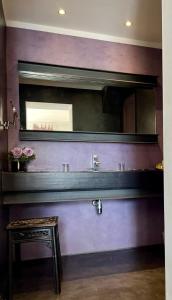 baño con espejo, mesa y taburete en LA MAISON DE JUSTINE en Grimaud