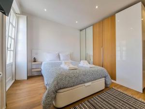 a bedroom with a bed and a large window at SAM - Studio in the city center in Viana do Castelo