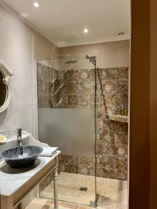uma casa de banho com uma cabina de duche em vidro e um lavatório. em LA MAISON DE JUSTINE em Grimaud