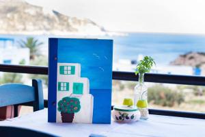 a table with a book and a vase with a house on it at Sea view apartment in Karpathos Town