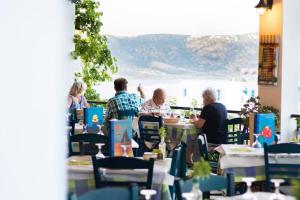 um grupo de pessoas sentadas numa mesa num restaurante em Sea view apartment em Cárpatos