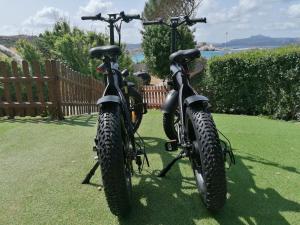 dos motos estacionadas una al lado de la otra en la hierba en B&B Il Corallo, en La Maddalena