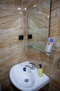 lavabo blanco en un baño con pared en Noravank L-and-L, en Aghavnadzor