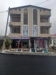 a building with portraits of two men in the windows at Orkide in Sheki