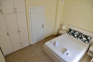 um pequeno quarto com uma cama branca e um lavatório em Lovely apartment em Alexandroupoli