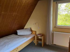 a small bedroom with a bed and a window at Ferienhaus Jurablick in Thalmässing