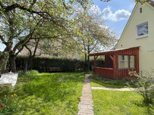 einen Garten mit einem Haus, einer Bank und Gras in der Unterkunft Ferienhaus Jurablick in Thalmässing