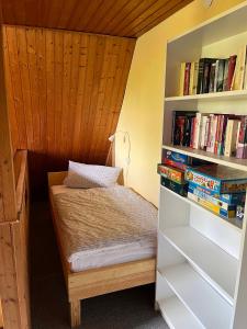 ein Schlafzimmer mit einem Bett und einem Bücherregal mit Büchern in der Unterkunft Ferienhaus Jurablick in Thalmässing