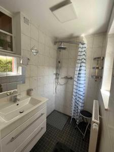 a white bathroom with a sink and a shower at Ferienhaus Jurablick in Thalmässing