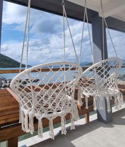 two white chairs hanging from a porch swing at Private Villa by the sea in Žuljana