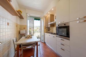 a kitchen with a table and chairs and a window at Victoria Apartment in Bordighera