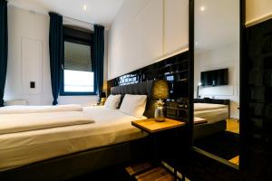 a hotel room with two beds and a mirror at Nikii Boutique Hotel in Leverkusen