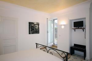 a white bedroom with a bed and a window at Cavalluccio Marino in Anacapri