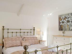 a bedroom with a bed and a painting on the wall at Sweet Pea Cottage in Llanelli