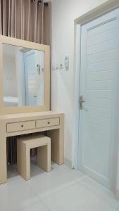 a bathroom with a vanity with a mirror and a door at Batik Oma House in Jetis