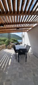 a patio with a table and chairs under a wooden ceiling at Private Villa by the sea in Žuljana