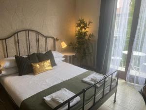 una camera da letto con un letto con lenzuola bianche e cuscini dorati di Ambra Boutique Hotel a Milano